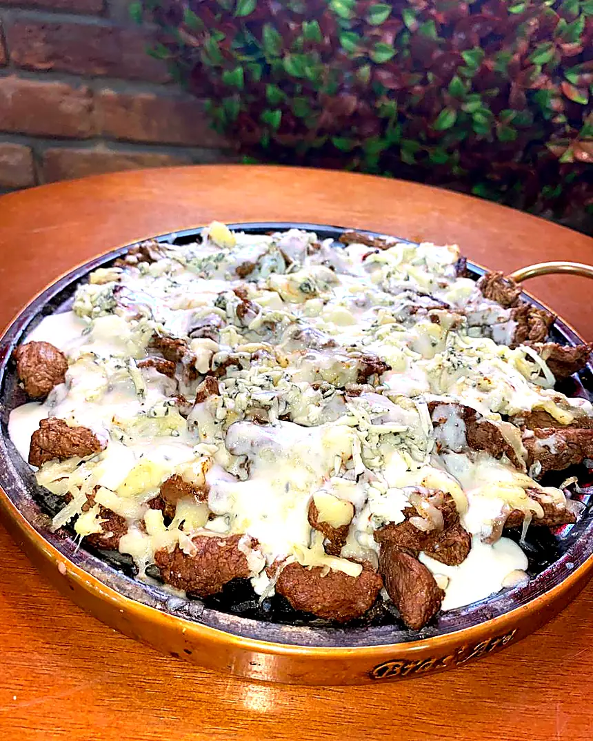Porção de carne com queijo na chapa